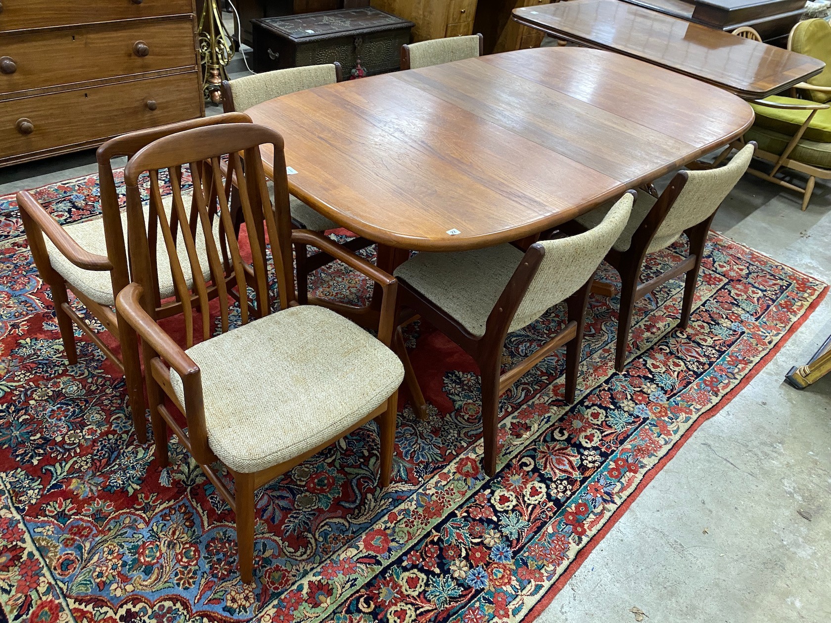 A mid century teak extending dining table, length 214cm extended, one spare leaf, width 108cm, height 75cm together with four teak dining chairs and two elbow chairs